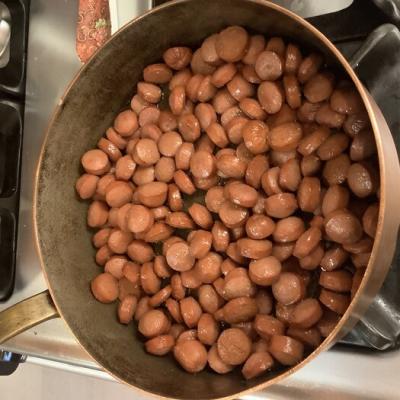 Hotdogs being sautéed to concentrate the flavor and remove some of the fat.